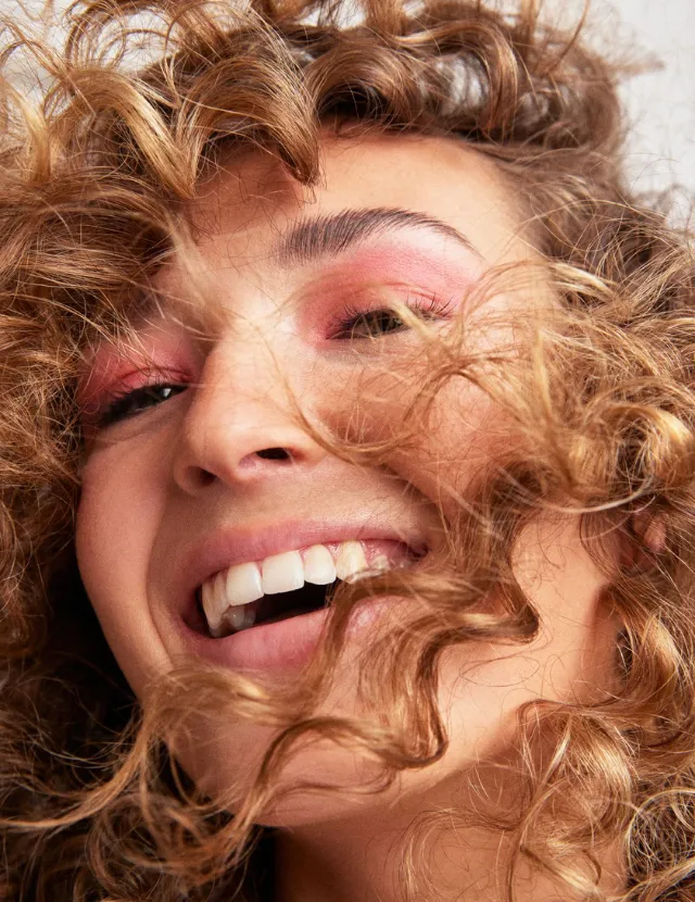 mujer con cabello rizado rubio