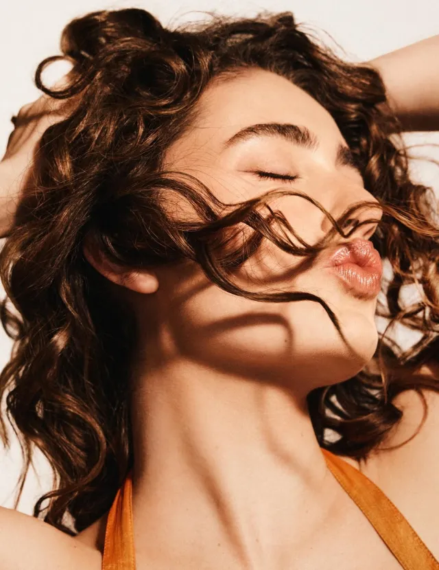 mujer con cabello ondulado castaño